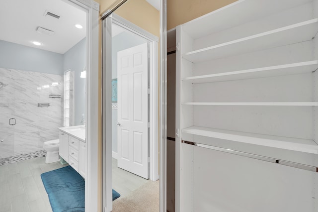 bathroom with vanity, toilet, and a shower with shower door