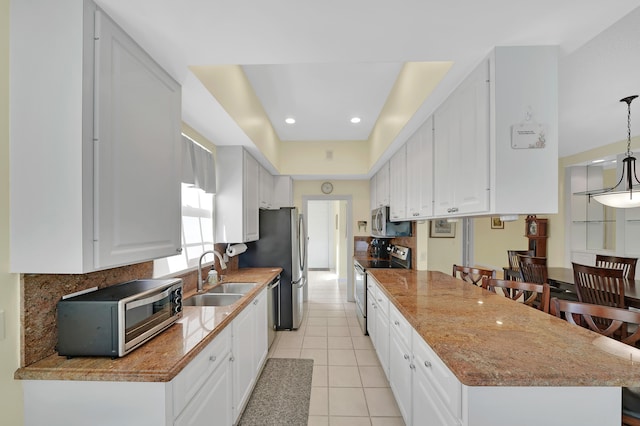 kitchen featuring stainless steel appliances, sink, pendant lighting, light tile patterned floors, and white cabinets