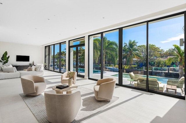 living room with floor to ceiling windows, a water view, a healthy amount of sunlight, and french doors