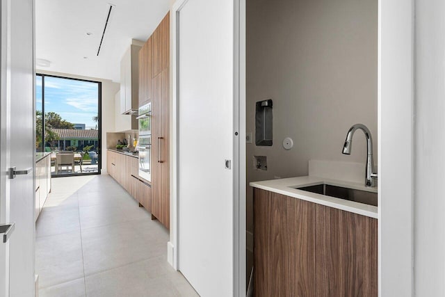 interior space with sink, oven, and a wall of windows