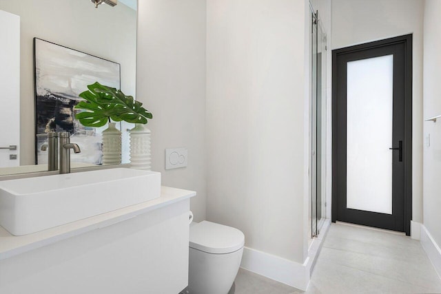 bathroom featuring vanity, toilet, and a shower with door