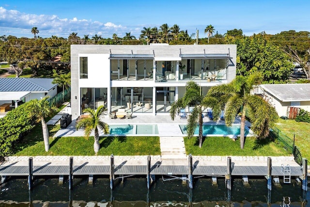 back of house featuring a yard, a balcony, a patio area, and a water view