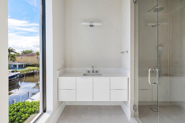 bathroom with tile patterned flooring, vanity, a water view, and an enclosed shower