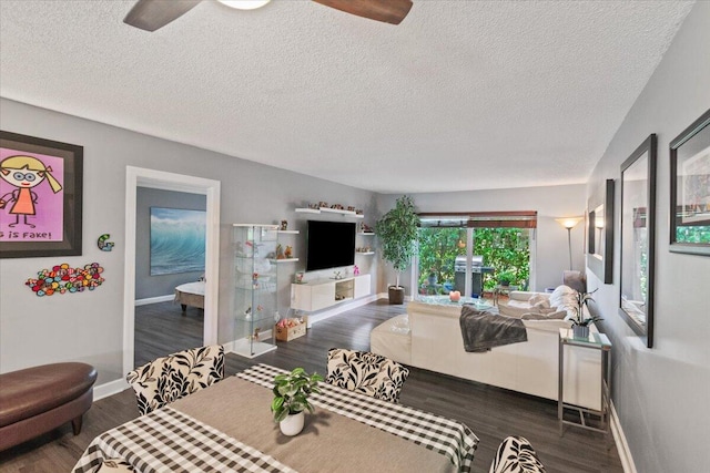 living room featuring a textured ceiling, dark hardwood / wood-style floors, and ceiling fan