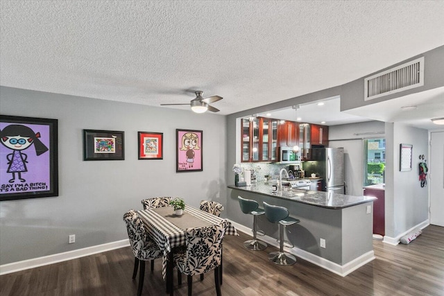 dining space with a textured ceiling, dark hardwood / wood-style floors, and ceiling fan