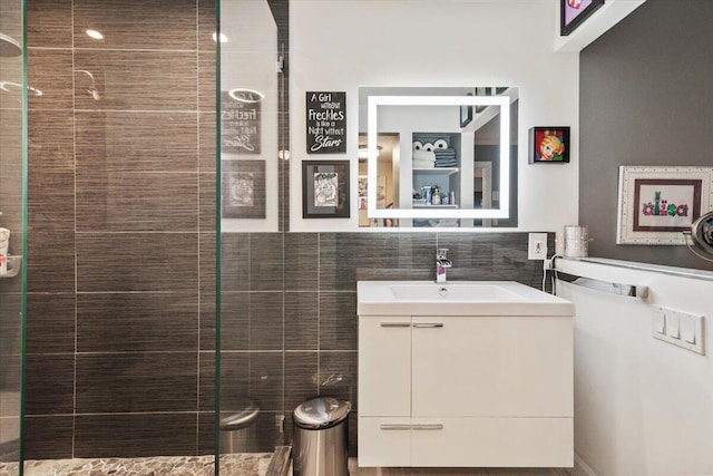 bathroom with vanity, tile walls, and tiled shower