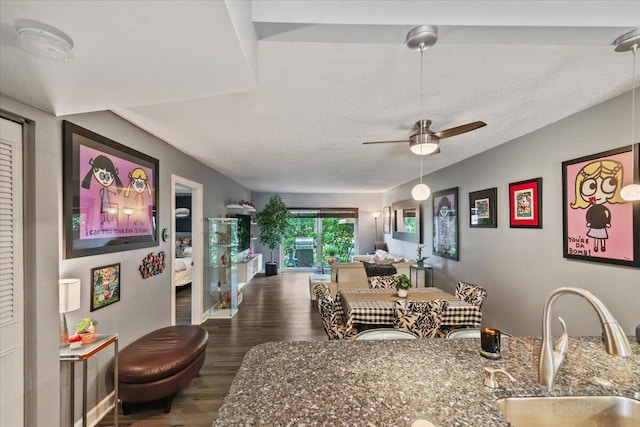 living room featuring a textured ceiling, ceiling fan, dark hardwood / wood-style flooring, and sink