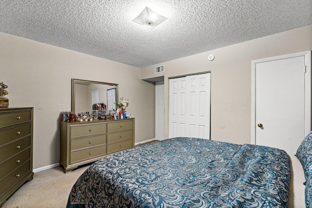 bedroom featuring a closet, light colored carpet, and a textured ceiling