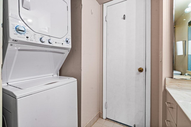 clothes washing area with light tile patterned floors and stacked washer / drying machine