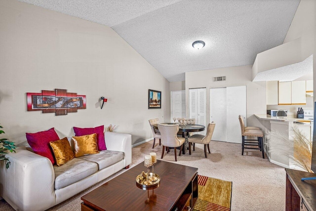 living room with a textured ceiling, lofted ceiling, and light carpet