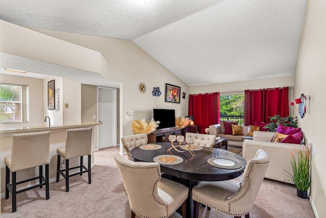 dining space with light carpet, a textured ceiling, and vaulted ceiling