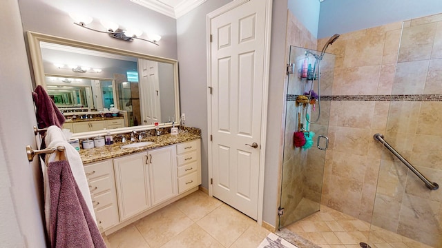 bathroom with vanity, ornamental molding, a shower with shower door, and tile patterned floors