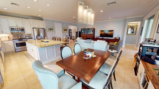 dining area with ornamental molding and light tile patterned floors