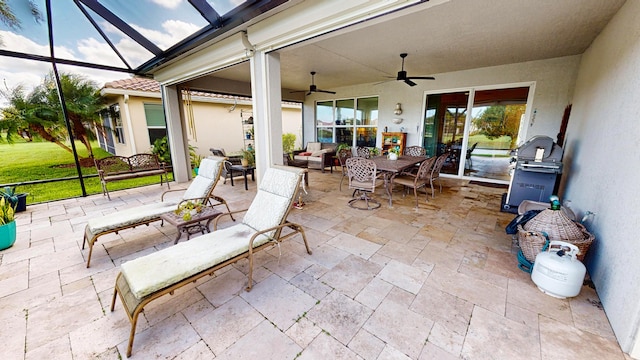 view of patio / terrace featuring a grill, ceiling fan, and glass enclosure