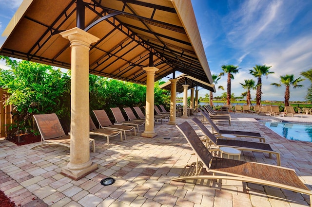 view of patio with a community pool and a gazebo