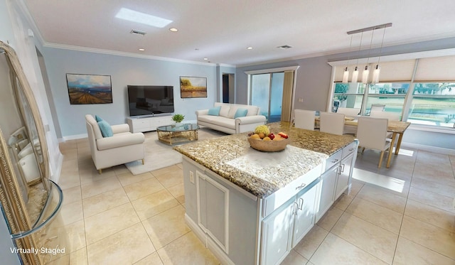 kitchen featuring white cabinetry, decorative light fixtures, light stone countertops, and a center island