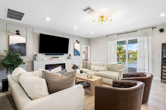 tiled living room featuring a textured ceiling and an inviting chandelier