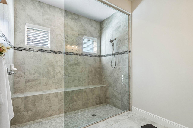 bathroom with tile patterned flooring and a tile shower