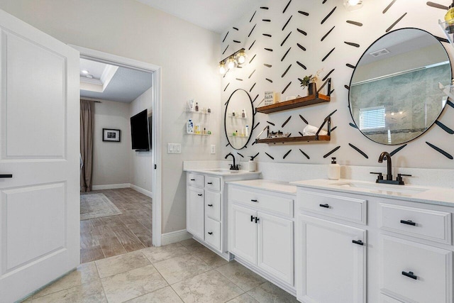 bathroom featuring vanity, hardwood / wood-style flooring, and a tray ceiling