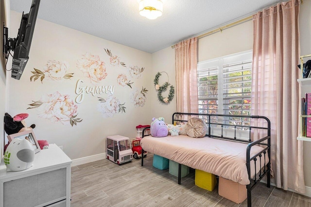 bedroom with light hardwood / wood-style floors and a textured ceiling