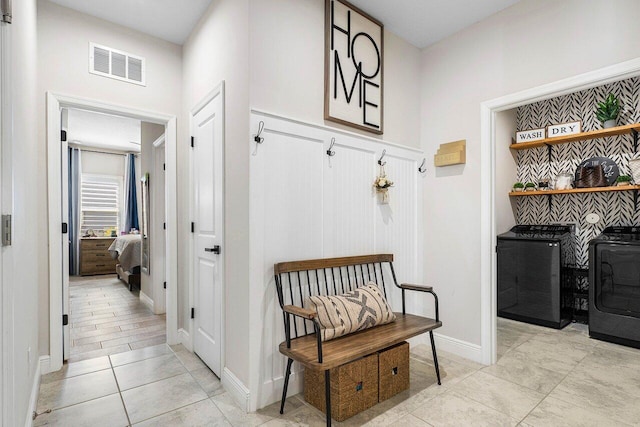 mudroom featuring independent washer and dryer and light tile patterned flooring