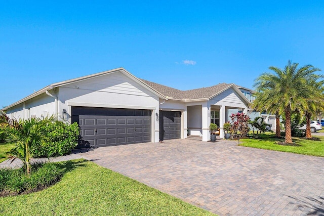 ranch-style home featuring a garage and a front lawn