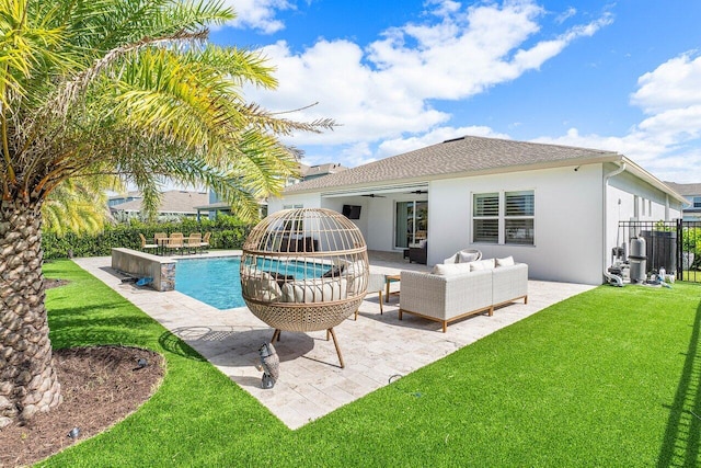 rear view of property featuring ceiling fan, a yard, an outdoor hangout area, a fenced in pool, and a patio area