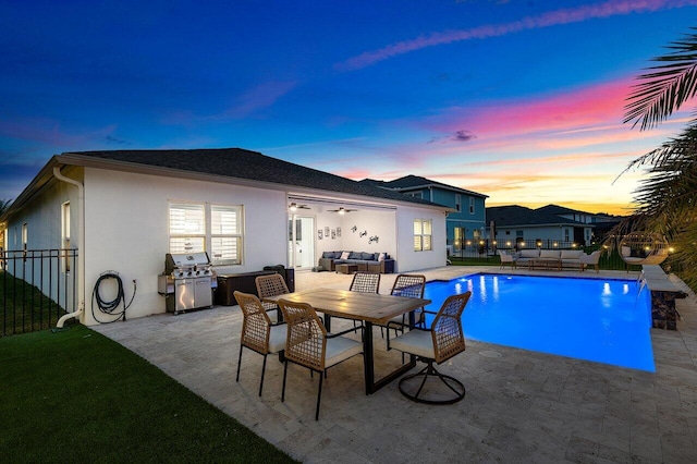 pool at dusk featuring pool water feature, an outdoor living space, a grill, and a patio area