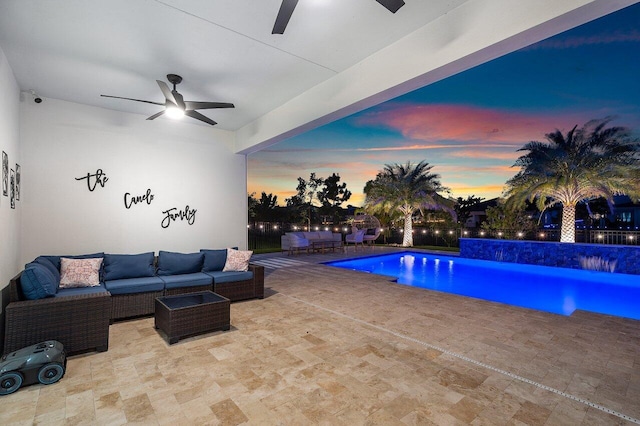 pool at dusk featuring an outdoor living space, a patio, and ceiling fan