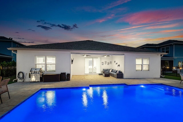 back house at dusk featuring an outdoor living space, ceiling fan, and a patio area