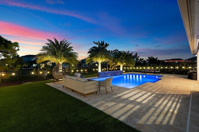 pool at dusk featuring a lawn, a patio area, and an outdoor hangout area