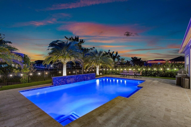 pool at dusk with a patio