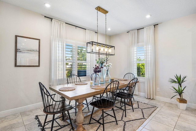 tiled dining area featuring plenty of natural light and a textured ceiling