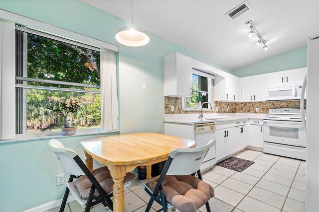 kitchen with white cabinets, decorative backsplash, white appliances, and sink