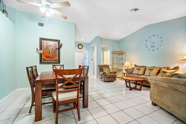 tiled dining room featuring ceiling fan and vaulted ceiling