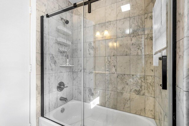 bathroom with bath / shower combo with glass door