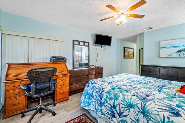 bedroom featuring a textured ceiling, light hardwood / wood-style floors, and ceiling fan