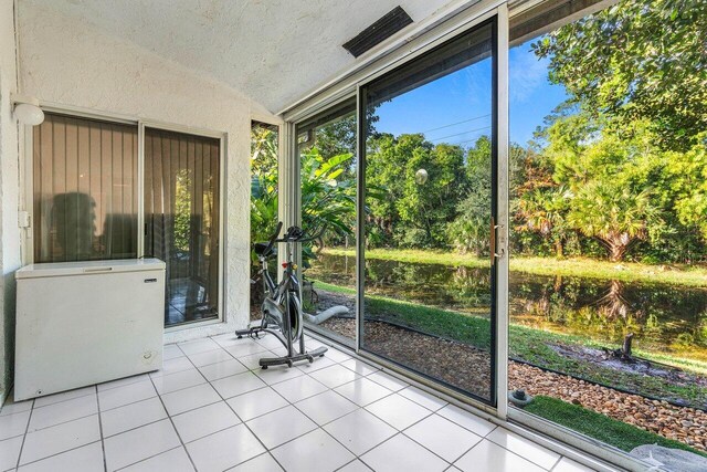 unfurnished sunroom featuring vaulted ceiling