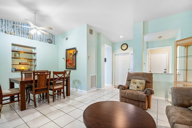 dining room with ceiling fan, light tile patterned floors, and lofted ceiling