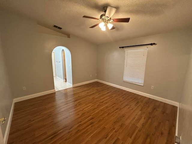 spare room featuring a textured ceiling, ceiling fan, and dark wood-type flooring