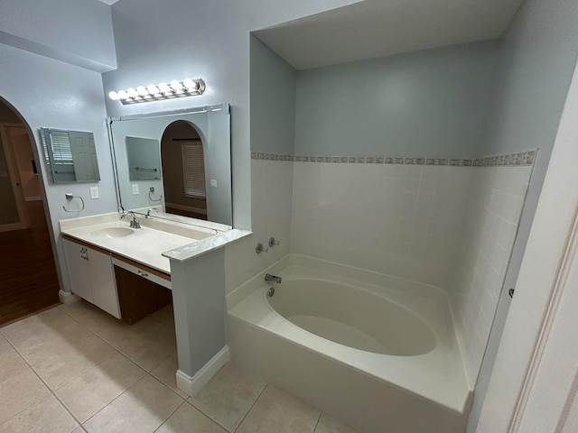 bathroom with a bathtub, vanity, and tile patterned flooring