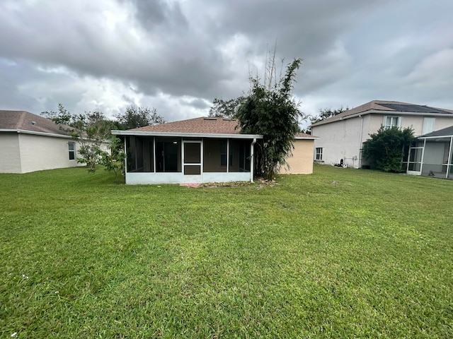 back of property with a sunroom and a yard