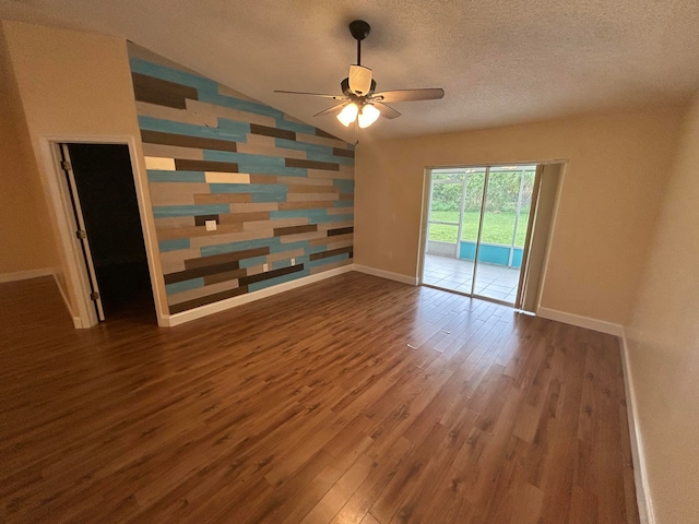 empty room featuring dark hardwood / wood-style floors, ceiling fan, a textured ceiling, and vaulted ceiling