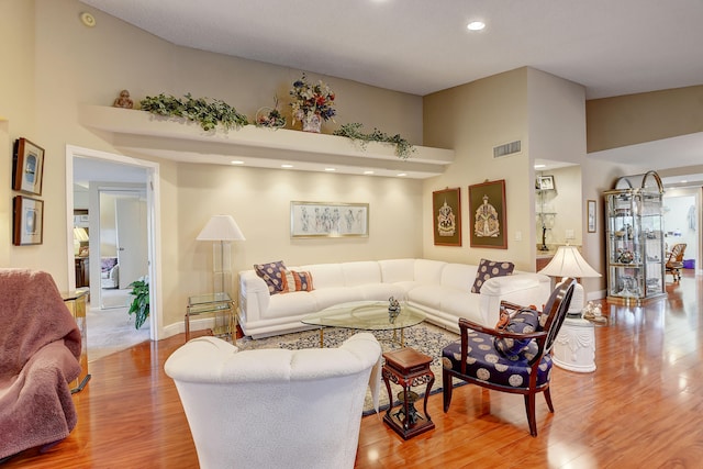 living room featuring high vaulted ceiling and hardwood / wood-style flooring