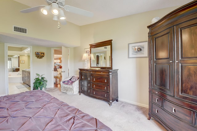 bedroom with ceiling fan, light carpet, and connected bathroom