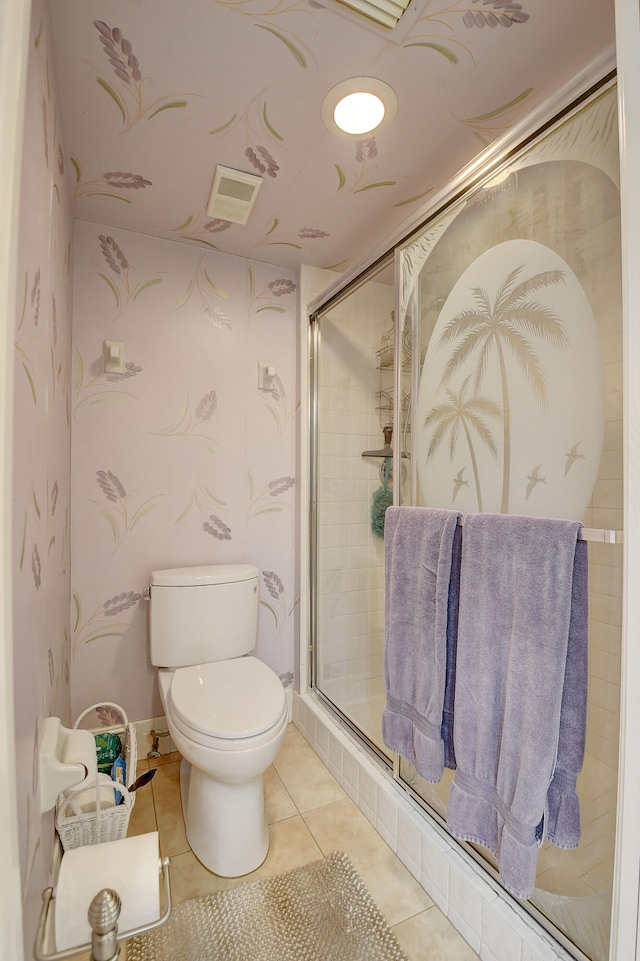 bathroom featuring toilet, tile patterned floors, and walk in shower