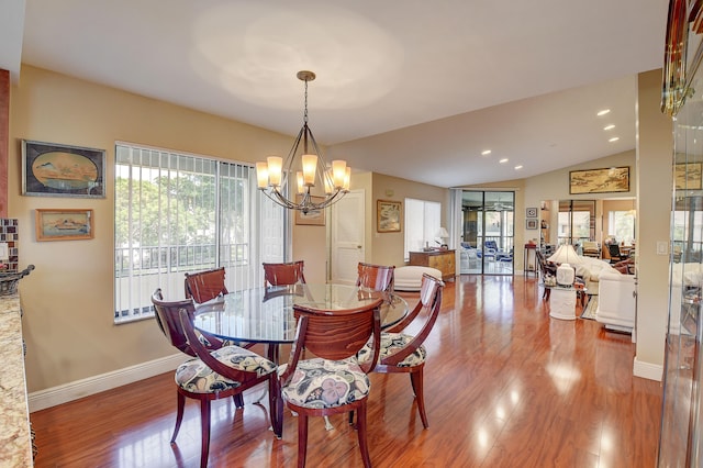 dining room with a notable chandelier, light hardwood / wood-style floors, and lofted ceiling