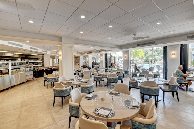 dining space featuring ceiling fan and decorative columns