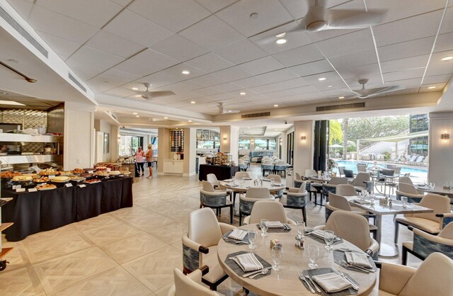 dining room featuring a wealth of natural light, ceiling fan, and a drop ceiling