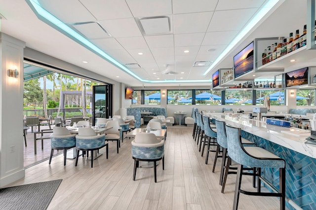 dining area with light hardwood / wood-style floors and a tray ceiling